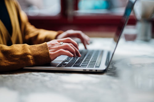 En person skriver på en laptop